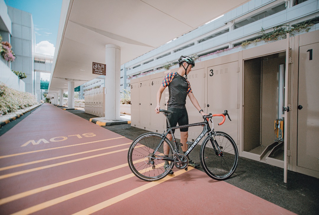 A cyclist storing his bicycle into the bicycle locker